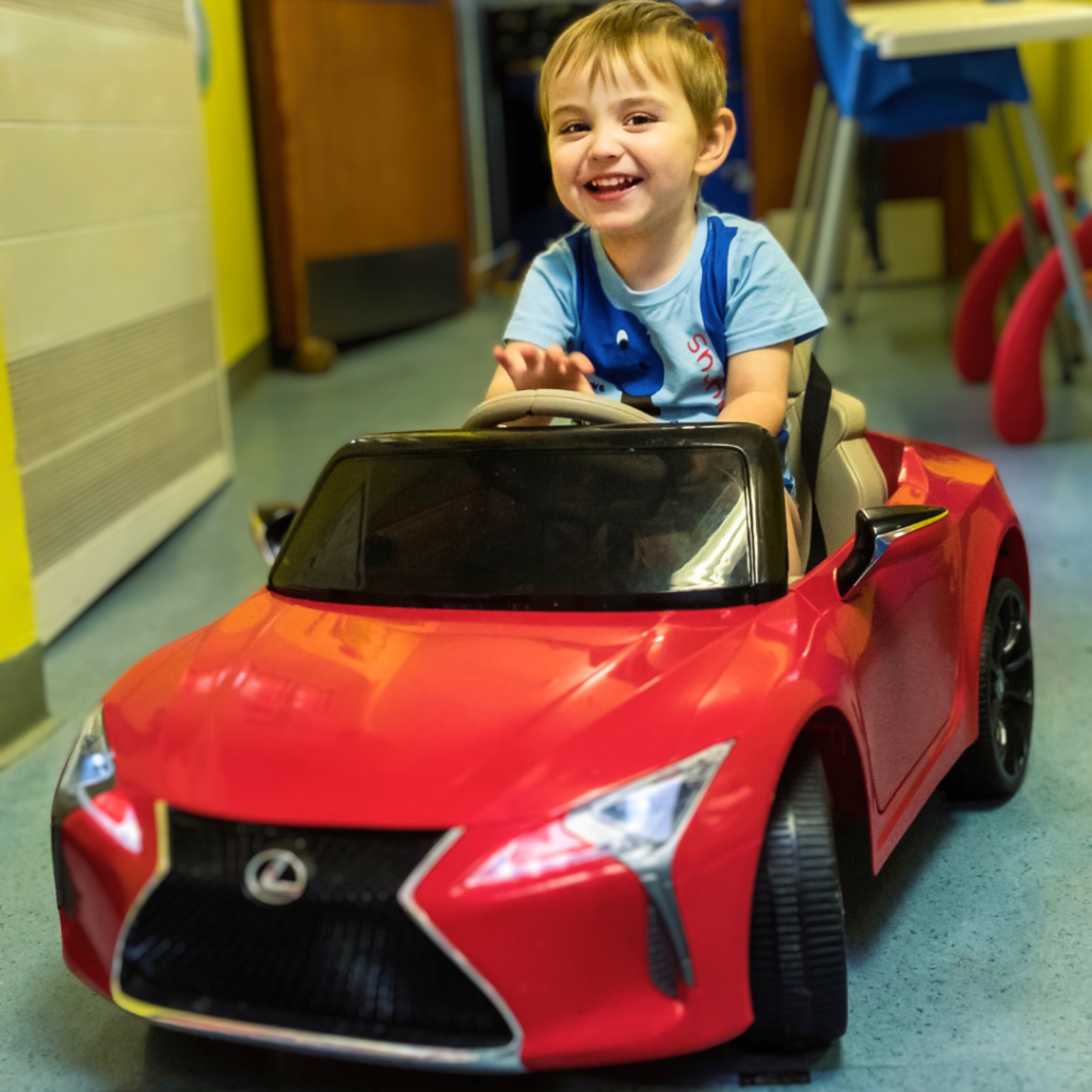 Child driving red lexus car